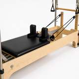 Bodylumina Premium Gold pilates tower reformer s drvenim okvirom, crnom kliznom platformom, metalnim tornjem, oprugama, trakama i podesivim footbar osloncem, profesionalna pilates sprava za tower reformer trening, jačanje core mišića, istezanje, stabilnost, rehabilitaciju i oblikovanje tijela kod kuće ili u studiju.
